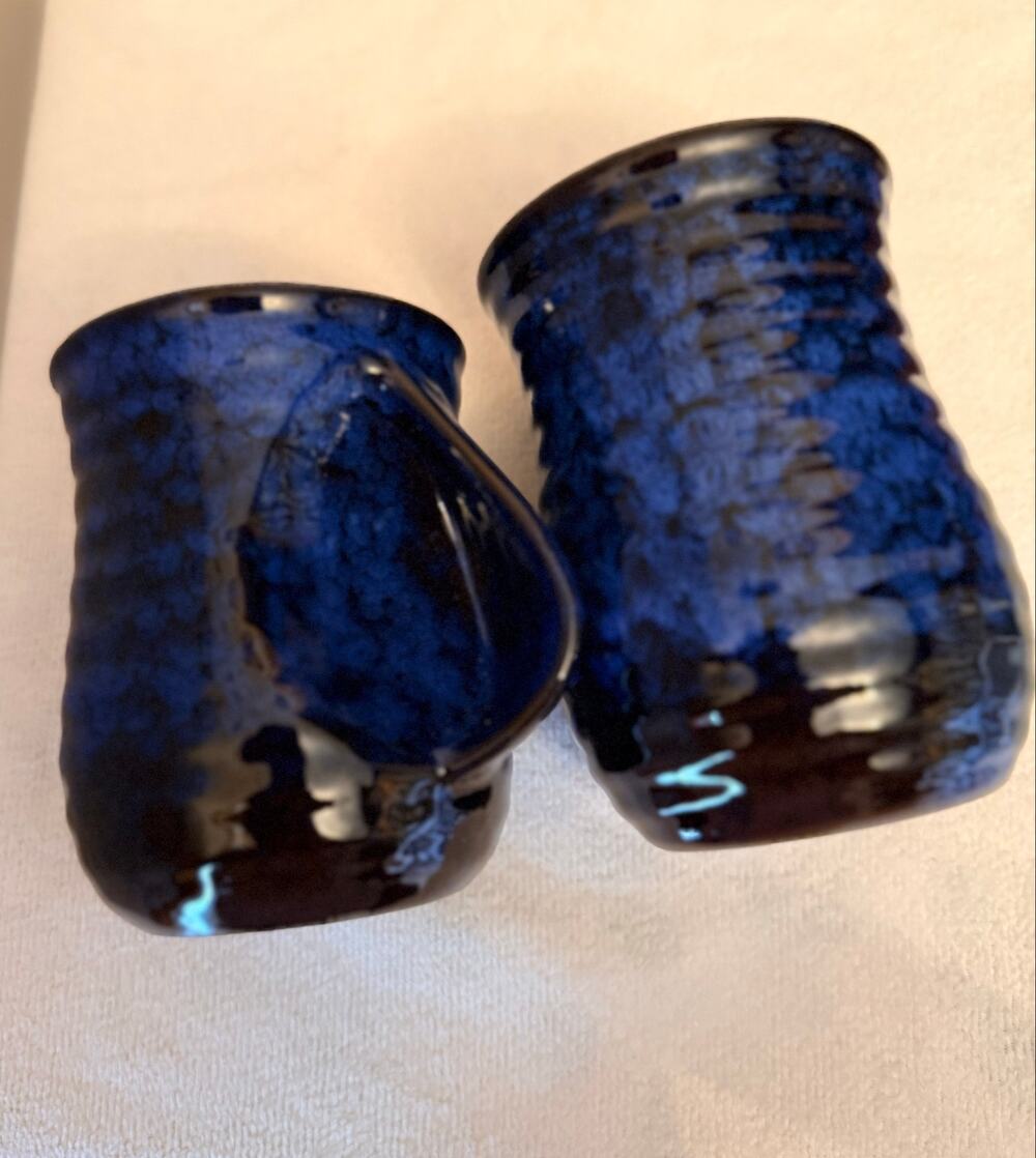 Two blue-black glazed studio pottery ceramic mugs functional hand-warmer pocket